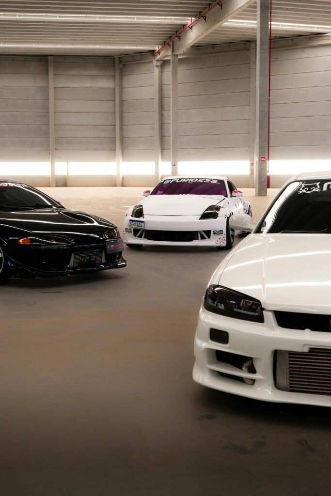 Three high-performance sports cars showcased in a modern indoor garage setup.